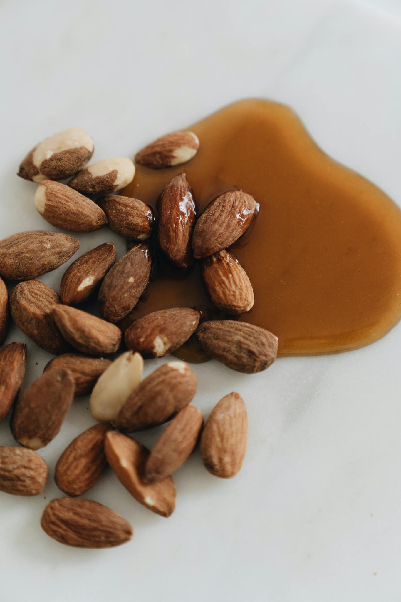 A delicious still life of almonds accompanied by a silky maple syrup pour, perfect for food photography.