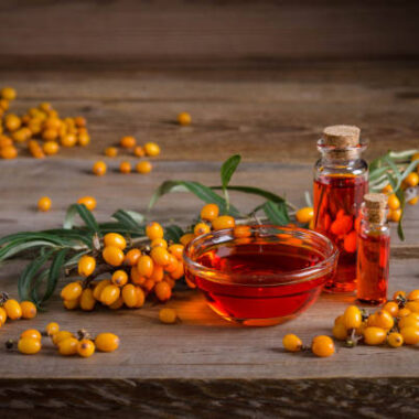 Sea buckthorn with bottle with sea buckthorn oil on wooden table